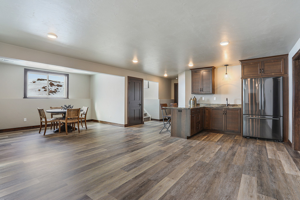 Open concept kitchen - huge transitional l-shaped light wood floor and brown floor open concept kitchen idea with an undermount sink, shaker cabinets, white cabinets, quartzite countertops, stainless steel appliances, an island and beige countertops