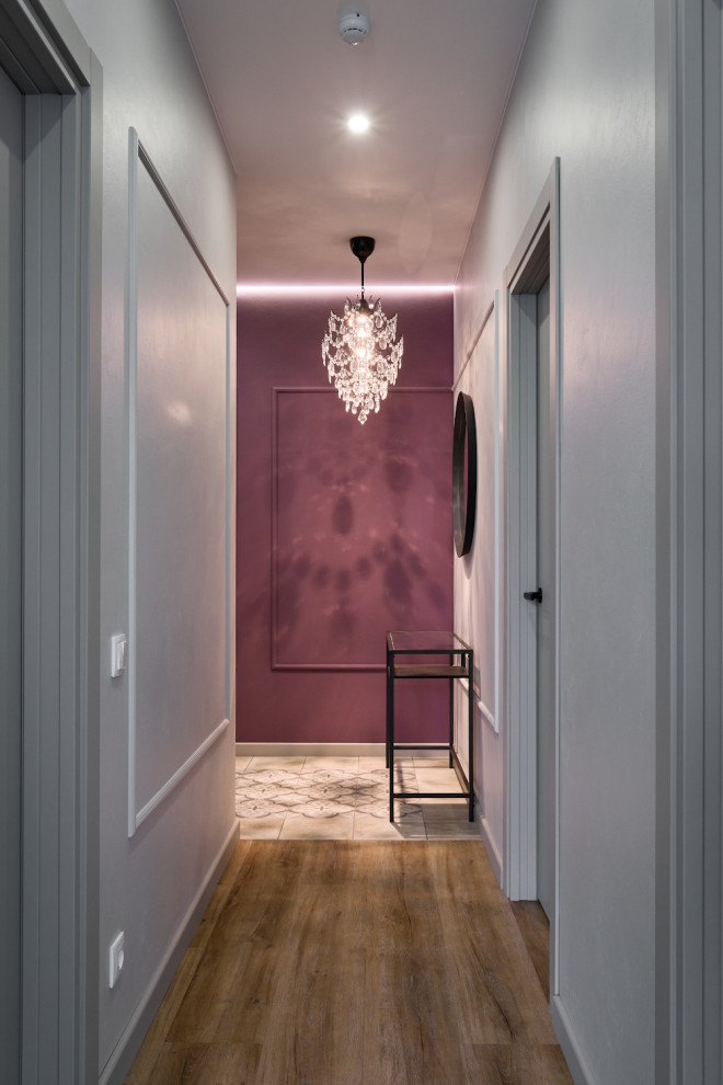 Пример оригинального дизайна: узкий, маленький коридор: освещение в современном стиле с полом из винила, панелями на части стены, фиолетовыми стенами и коричневым полом для на участке и в саду