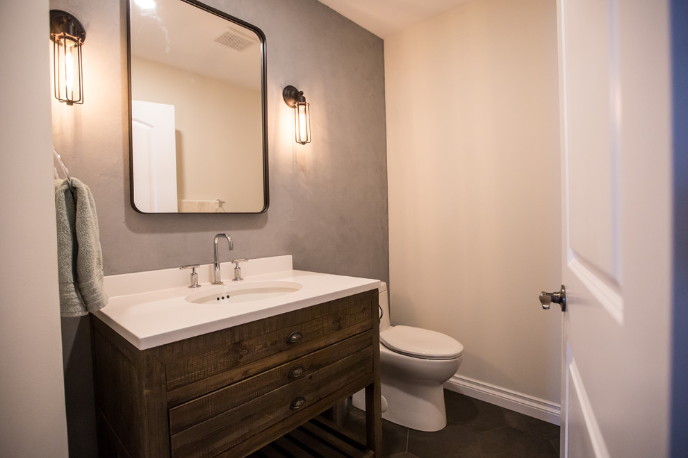 This is an example of a mid-sized contemporary powder room in Edmonton with flat-panel cabinets, medium wood cabinets, a one-piece toilet, gray tile, porcelain tile, grey walls, porcelain floors, an undermount sink and engineered quartz benchtops.