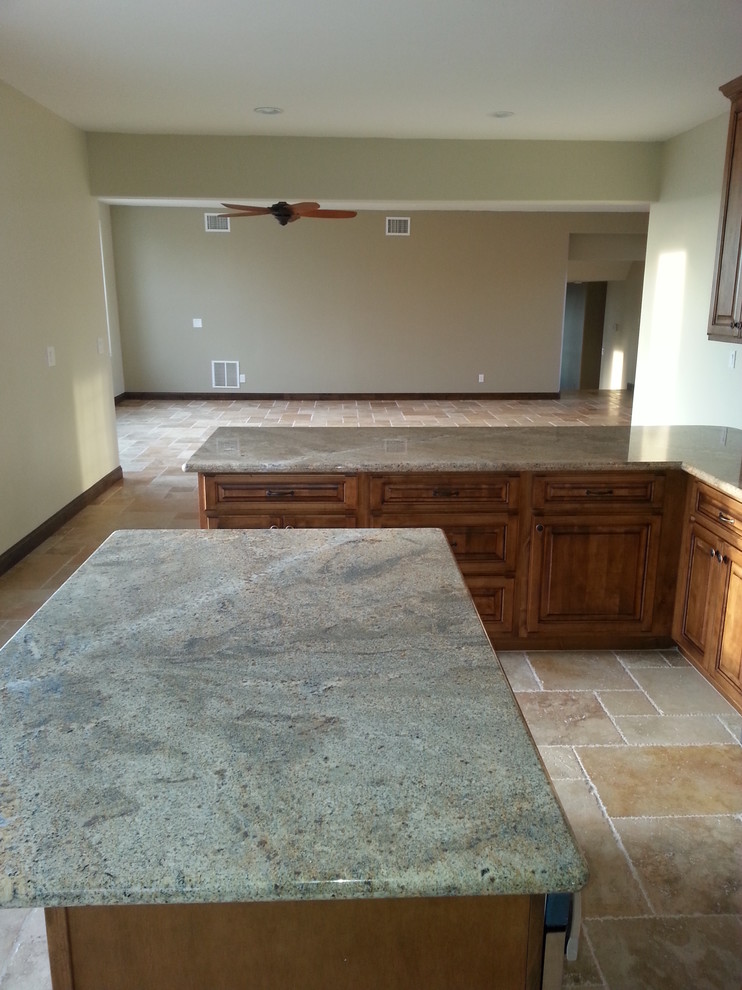 Example of a tuscan travertine floor open concept kitchen design in Phoenix with raised-panel cabinets, medium tone wood cabinets, granite countertops and an island