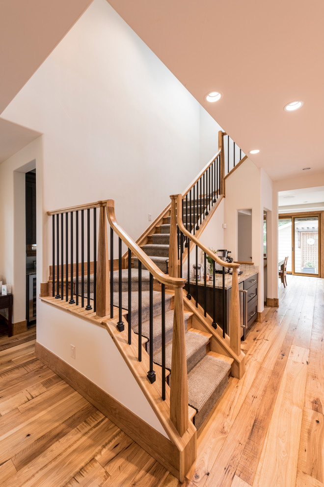 Large transitional wood u-shaped staircase in Denver with wood risers and wood railing.