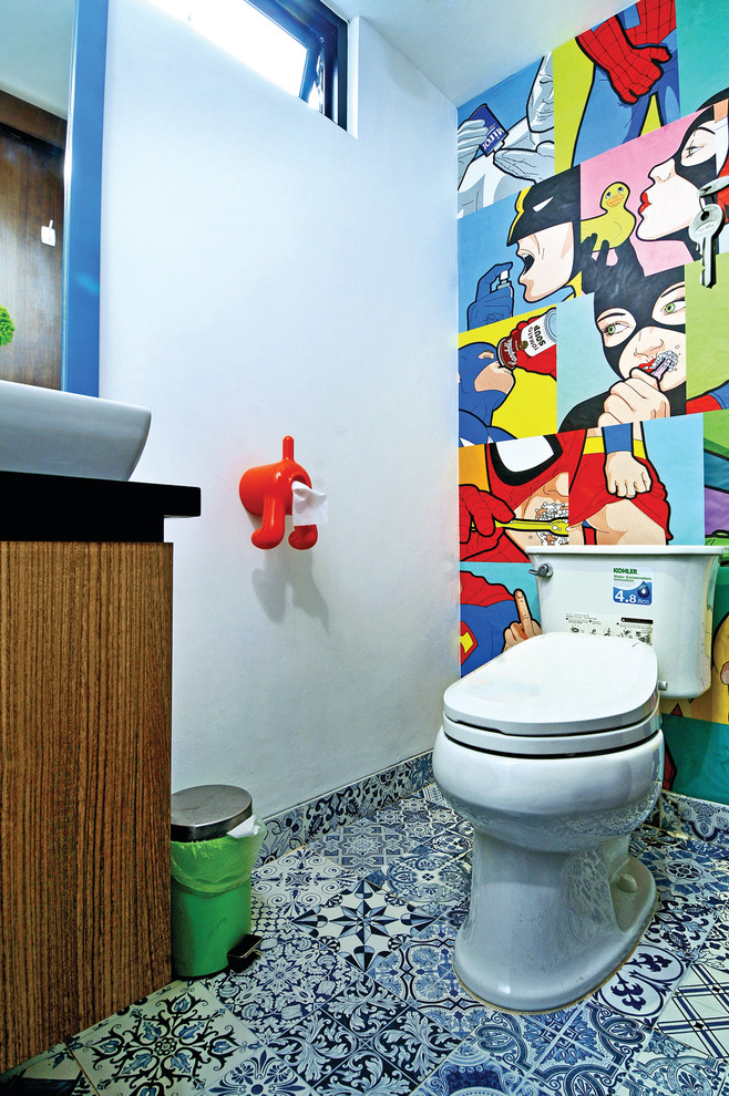Small contemporary powder room in Other with flat-panel cabinets, medium wood cabinets, a two-piece toilet, ceramic floors, multi-coloured walls and a vessel sink.