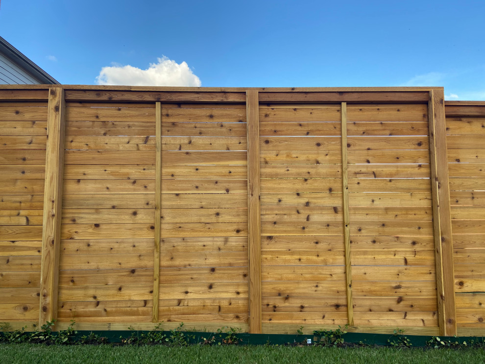 Design ideas for a large back garden with a wood fence.