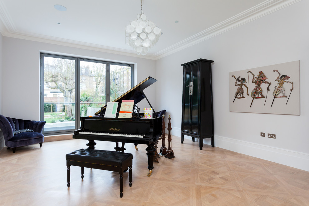 Photo of a large transitional living room in London with a music area, white walls, light hardwood floors, no fireplace and no tv.