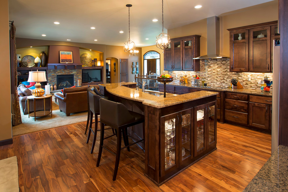 Inspiration for a transitional l-shaped medium tone wood floor open concept kitchen remodel with an undermount sink, recessed-panel cabinets, dark wood cabinets, granite countertops, multicolored backsplash, mosaic tile backsplash, stainless steel appliances and an island
