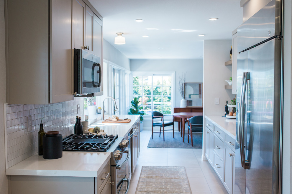 Open concept kitchen - small transitional galley porcelain tile and beige floor open concept kitchen idea in Orange County with a double-bowl sink, shaker cabinets, beige cabinets, quartz countertops, white backsplash, subway tile backsplash, stainless steel appliances, no island and white countertops