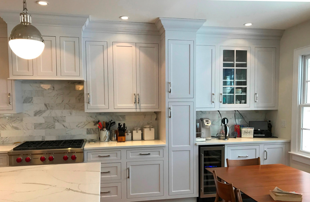 Large transitional u-shaped medium tone wood floor and brown floor eat-in kitchen photo with a farmhouse sink, recessed-panel cabinets, white cabinets, quartz countertops, white backsplash, subway tile backsplash, stainless steel appliances, an island and white countertops