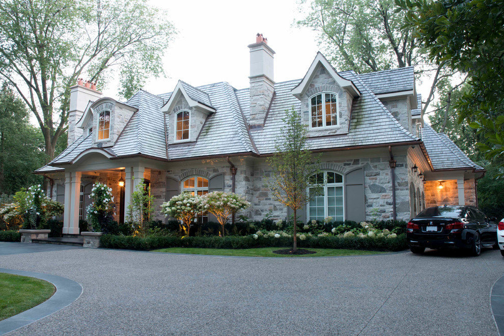 Inspiration for a traditional front yard driveway in Toronto with a garden path and natural stone pavers.