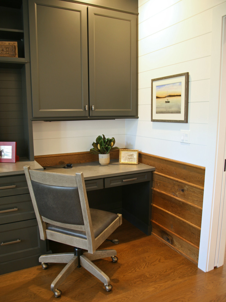 Photo of a mid-sized beach style study room in Milwaukee with white walls, medium hardwood floors, a built-in desk, brown floor and decorative wall panelling.