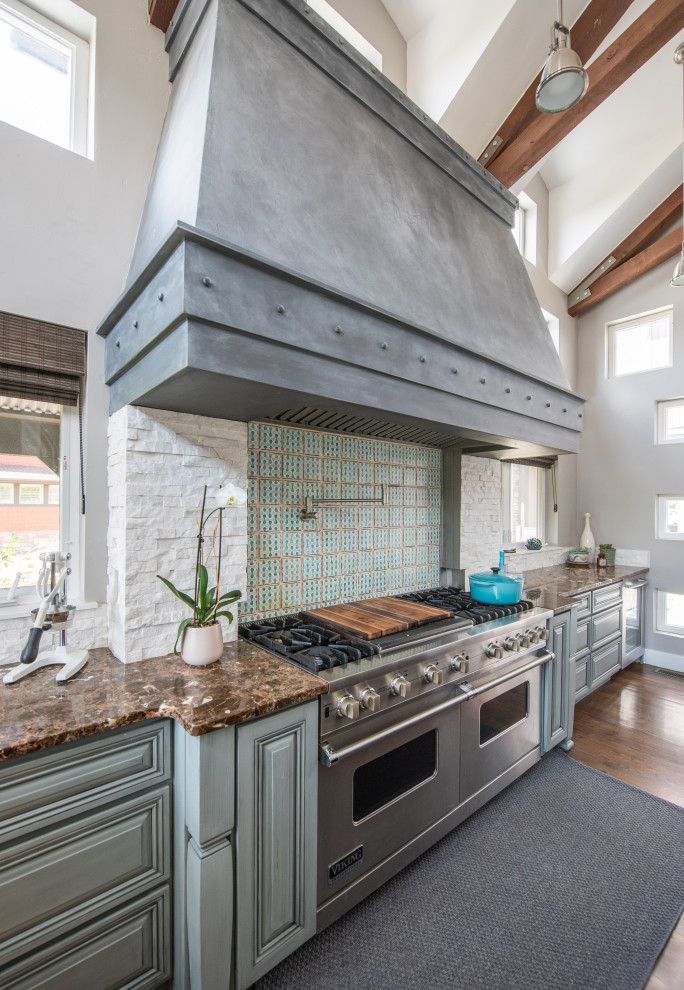 Foto på ett eklektiskt kök, med luckor med upphöjd panel, turkosa skåp, granitbänkskiva, blått stänkskydd, stänkskydd i stenkakel, rostfria vitvaror, mellanmörkt trägolv och flera köksöar
