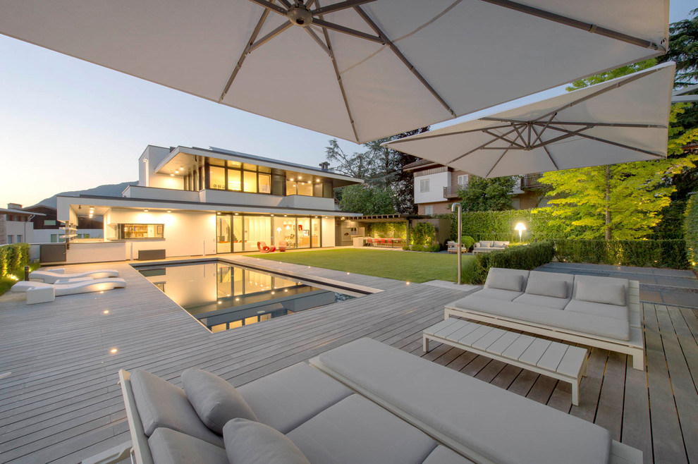 Large contemporary backyard deck in Bologna with an awning.