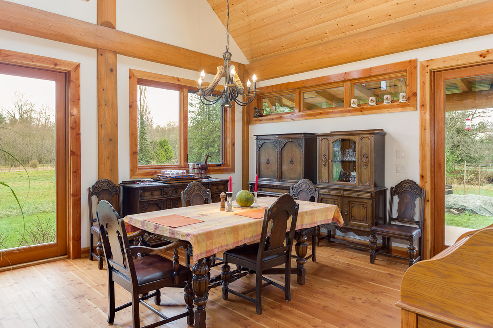 Photo of a mid-sized country dining room in Vancouver with white walls and medium hardwood floors.