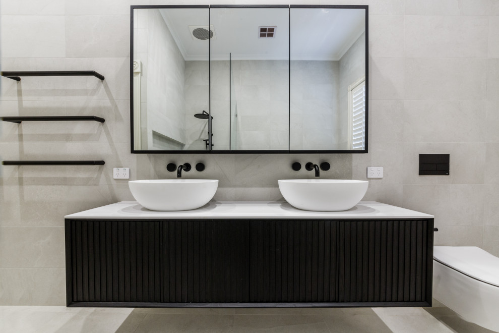 Design ideas for a large contemporary kids wet room bathroom in Melbourne with dark wood cabinets, a freestanding tub, gray tile, porcelain tile, porcelain floors, a vessel sink, marble benchtops, grey floor, a hinged shower door, white benchtops, a double vanity and a floating vanity.