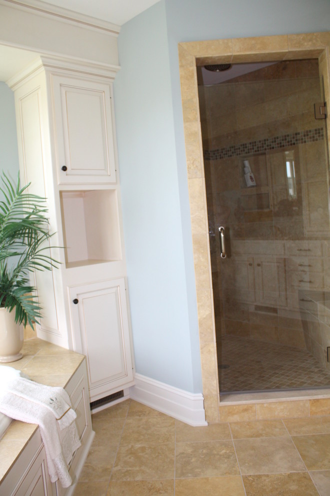 Drop-in bathtub - large transitional master porcelain tile and multicolored floor drop-in bathtub idea with raised-panel cabinets, white cabinets, blue walls, an undermount sink, quartz countertops and a hinged shower door