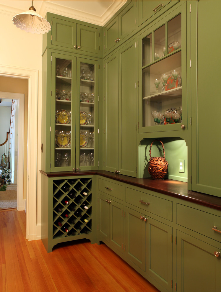 Photo of a small traditional single-wall eat-in kitchen in Other with glass-front cabinets, green cabinets, wood benchtops, medium hardwood floors, no island, green splashback, timber splashback and brown floor.