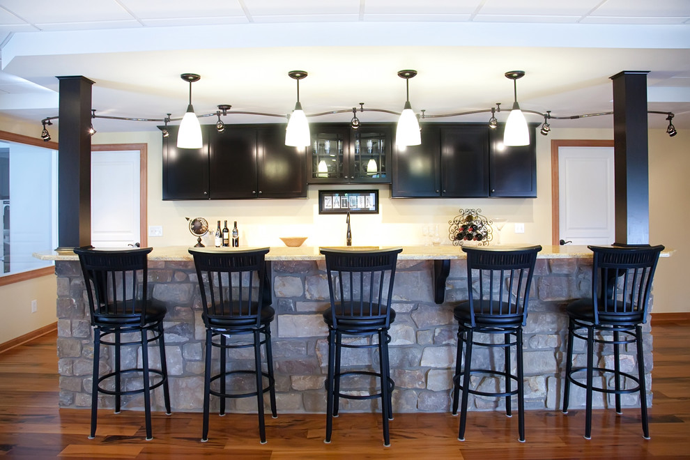 Photo of a mid-sized transitional u-shaped seated home bar in Philadelphia with shaker cabinets, black cabinets, granite benchtops and an undermount sink.
