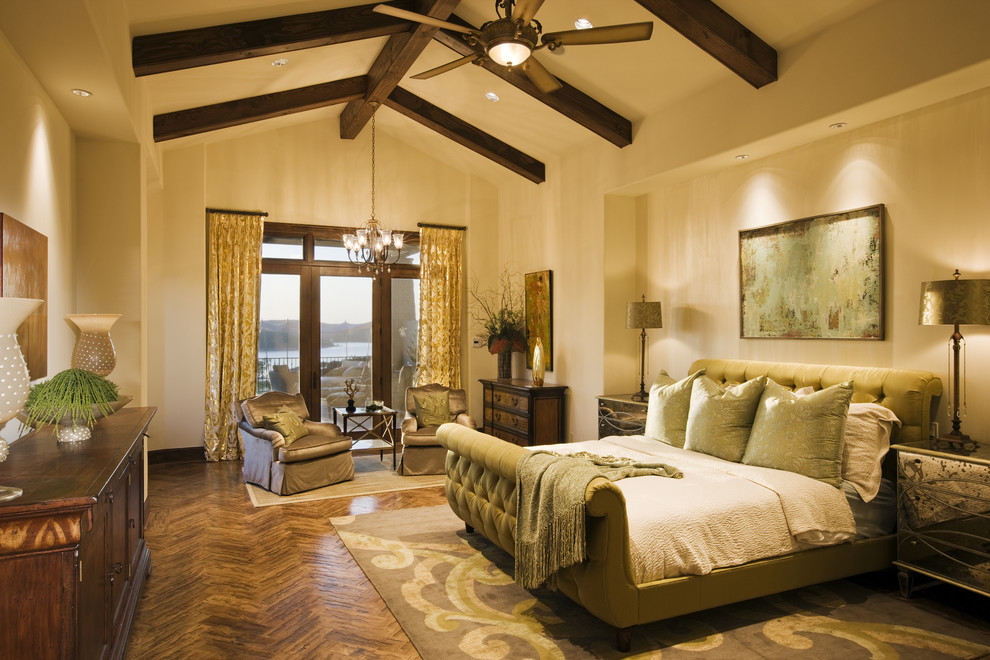 Inspiration for a mediterranean master bedroom in Austin with beige walls and medium hardwood floors.