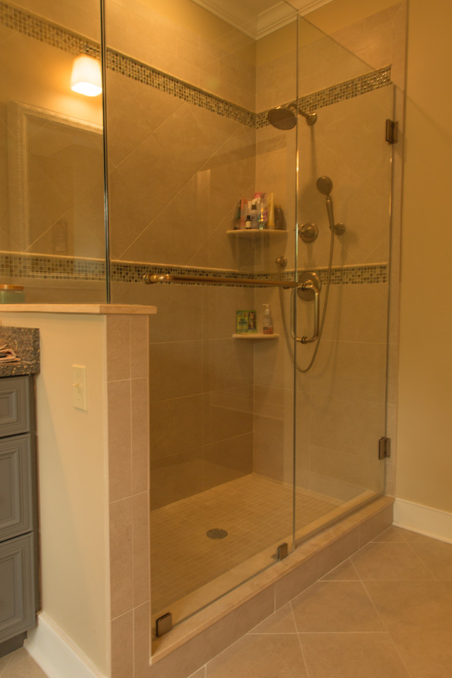 Photo of a mid-sized traditional bathroom in New York with an undermount sink, raised-panel cabinets, green cabinets, granite benchtops, a corner shower, a two-piece toilet, green tile, stone slab, beige walls and marble floors.