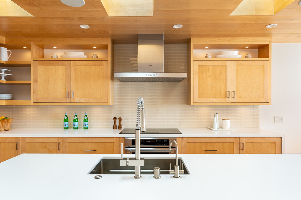 Photo of an expansive contemporary galley open plan kitchen in Los Angeles with a single-bowl sink, shaker cabinets, light wood cabinets, quartz benchtops, beige splashback, glass tile splashback, stainless steel appliances, light hardwood floors, with island, yellow floor and white benchtop.