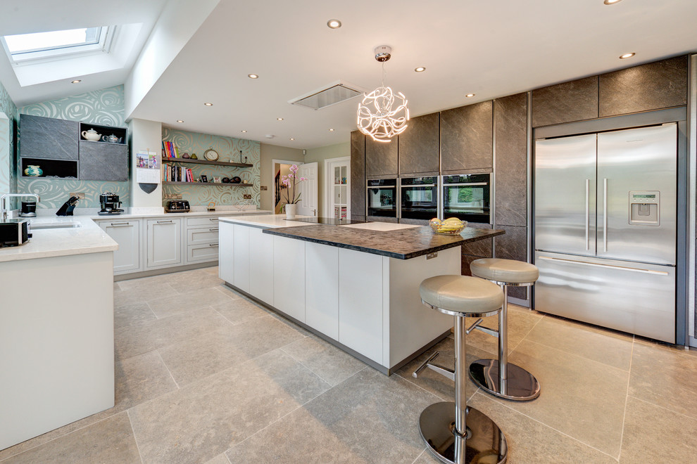 Design ideas for a large contemporary u-shaped kitchen in London with an undermount sink, flat-panel cabinets, brown cabinets, stainless steel appliances, with island, grey floor and brown benchtop.