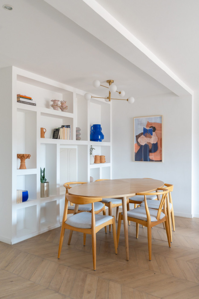 Immagine di una sala da pranzo moderna con pareti bianche, parquet chiaro e pavimento beige