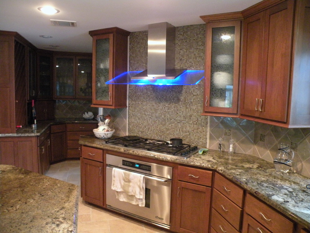 Mid-sized transitional u-shaped limestone floor eat-in kitchen photo in Houston with an undermount sink, shaker cabinets, medium tone wood cabinets, granite countertops, beige backsplash, mosaic tile backsplash, stainless steel appliances and an island