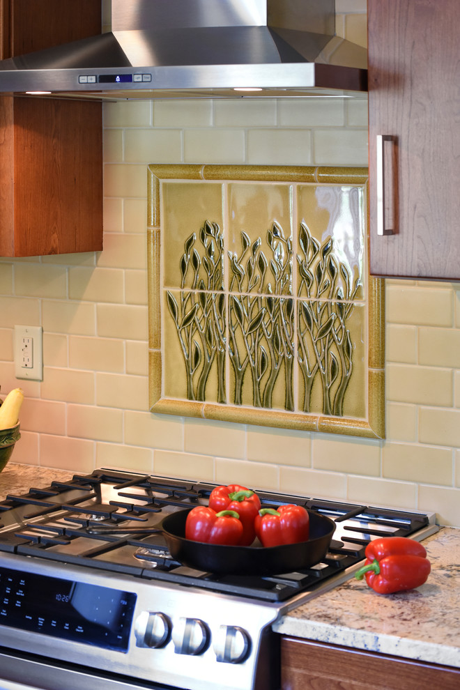 Mid-sized transitional galley light wood floor enclosed kitchen photo with a farmhouse sink, flat-panel cabinets, medium tone wood cabinets, granite countertops, yellow backsplash, ceramic backsplash, stainless steel appliances and no island