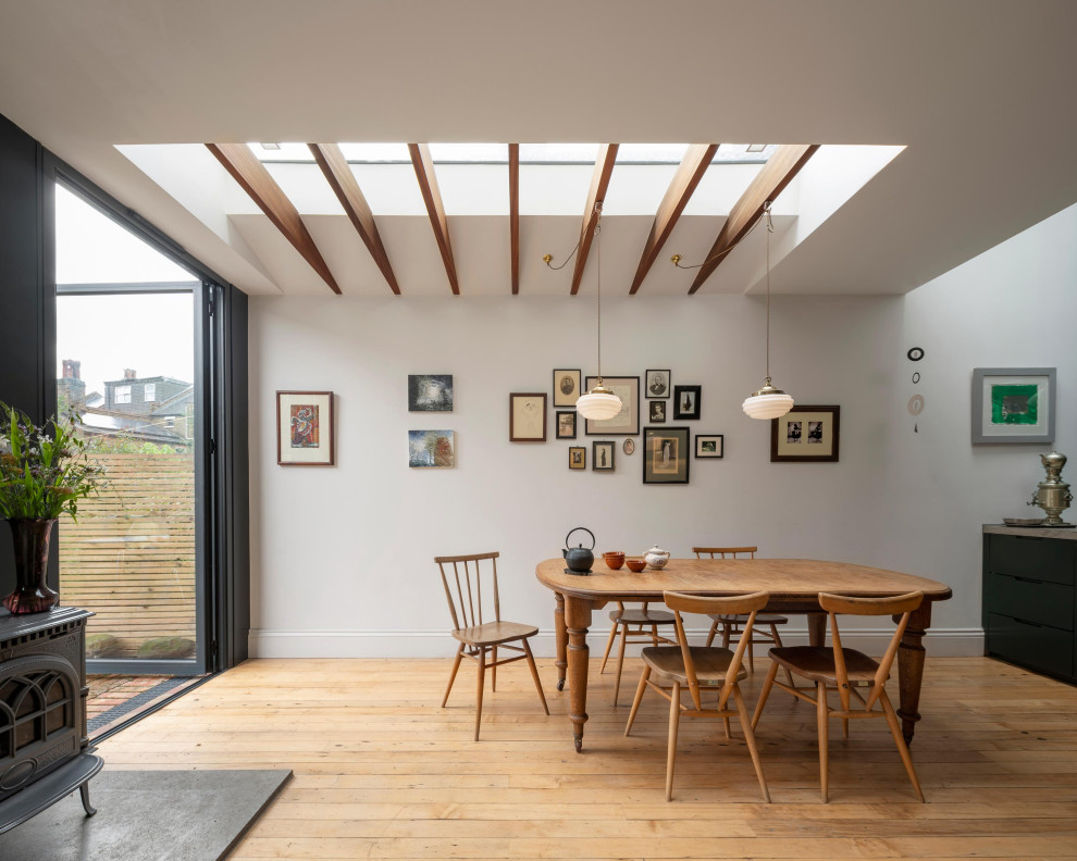 Идея дизайна: столовая в современном стиле с белыми стенами, паркетным полом среднего тона, коричневым полом и балками на потолке