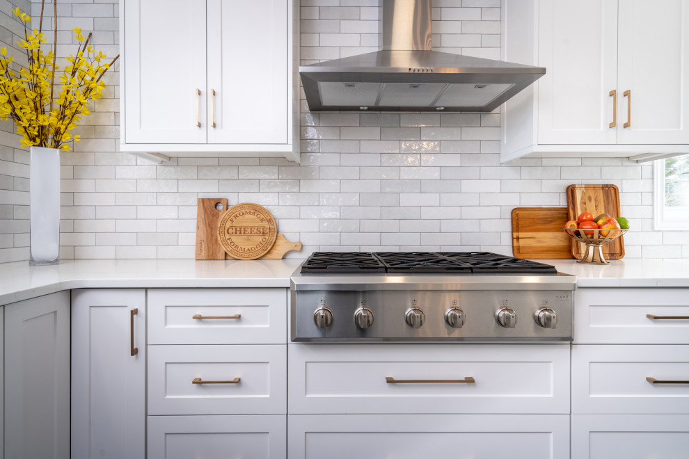 Inspiration for a mid-sized transitional l-shaped ceramic tile and gray floor eat-in kitchen remodel with an undermount sink, white cabinets, quartz countertops, white backsplash, ceramic backsplash, stainless steel appliances, an island and white countertops