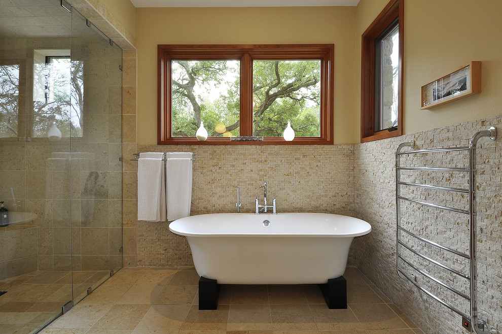 Contemporary bathroom in Austin with a freestanding tub and stone tile.