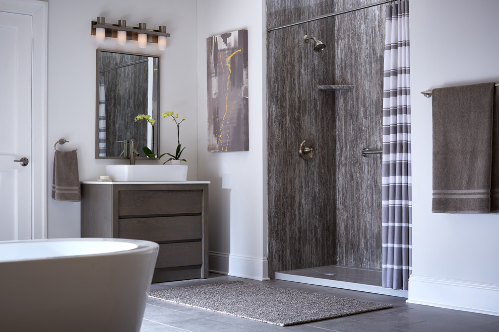 Large modern master bathroom in Boston with flat-panel cabinets, brown cabinets, a freestanding tub, an alcove shower, gray tile, stone slab, white walls, concrete floors, a vessel sink, engineered quartz benchtops, grey floor and a shower curtain.