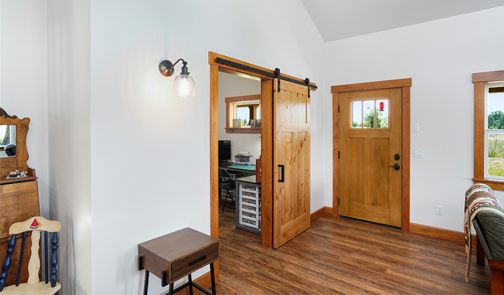 Große Rustikale Haustür mit weißer Wandfarbe, braunem Holzboden, Einzeltür, hellbrauner Holzhaustür, braunem Boden und gewölbter Decke in Sonstige
