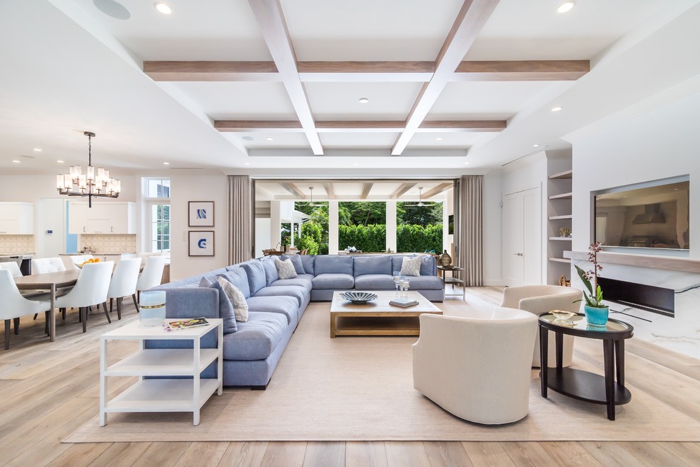 This is an example of a transitional open concept family room in Miami with white walls, light hardwood floors, a ribbon fireplace and a wall-mounted tv.