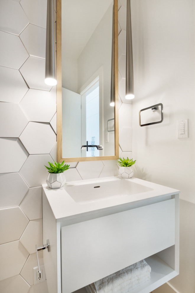 Design ideas for a small modern powder room in Vancouver with open cabinets, white cabinets, a one-piece toilet, white tile, porcelain tile, white walls, light hardwood floors, an integrated sink, solid surface benchtops, yellow floor and white benchtops.