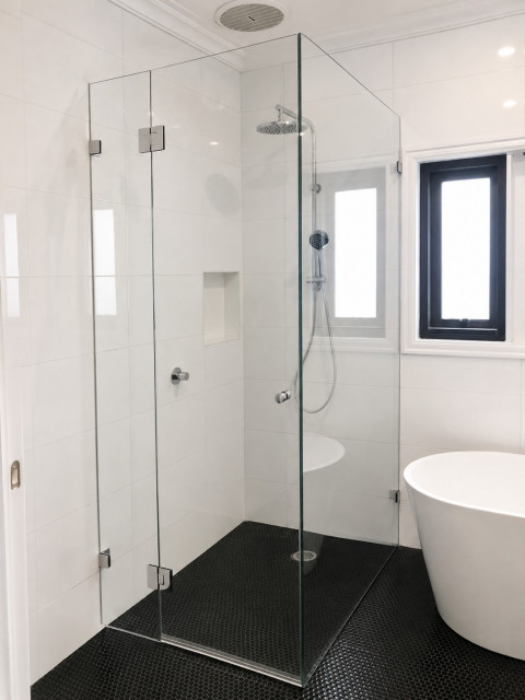 Low iron frameless shower screen with chrome hardware in Sunshine contemporary-bathroom