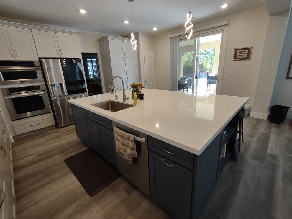 Kitchen - large transitional l-shaped kitchen idea in Las Vegas with shaker cabinets, white cabinets, quartz countertops, an island and white countertops