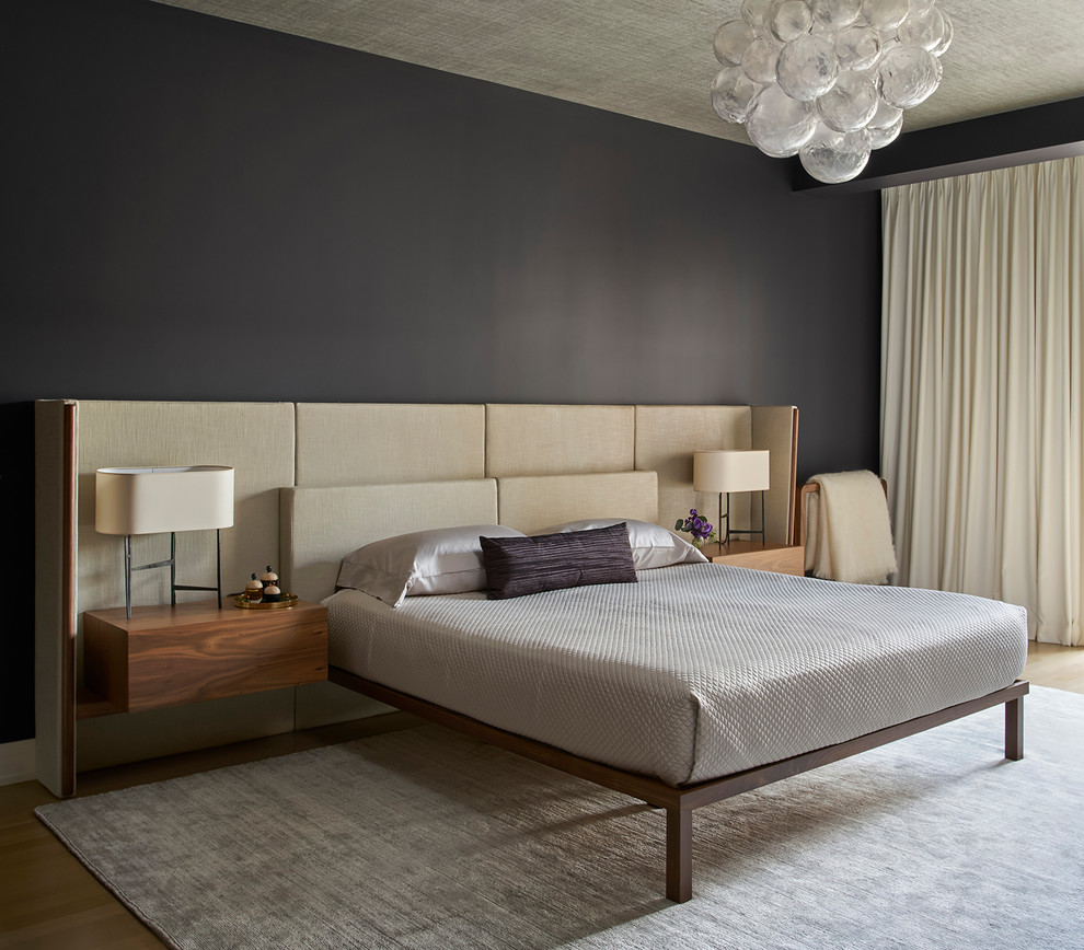 Contemporary bedroom in Chicago with black walls, medium hardwood floors and brown floor.