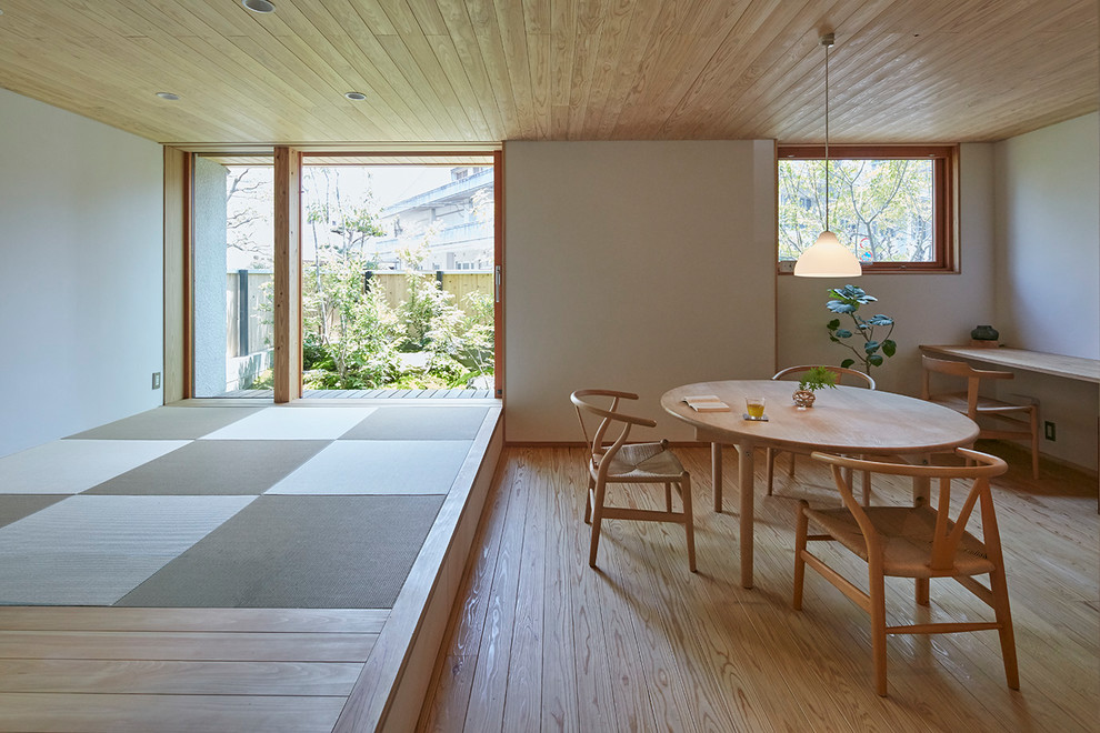 Asian open plan dining in Fukuoka with white walls, medium hardwood floors and brown floor.