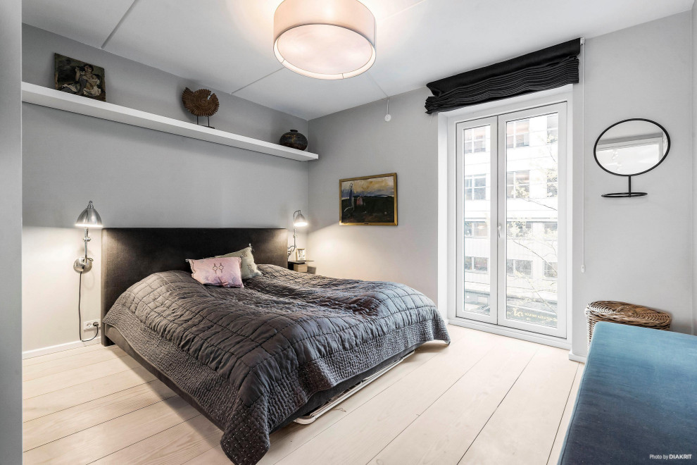 Inspiration for a mid-sized modern master bedroom in Copenhagen with light hardwood floors and multi-coloured floor.