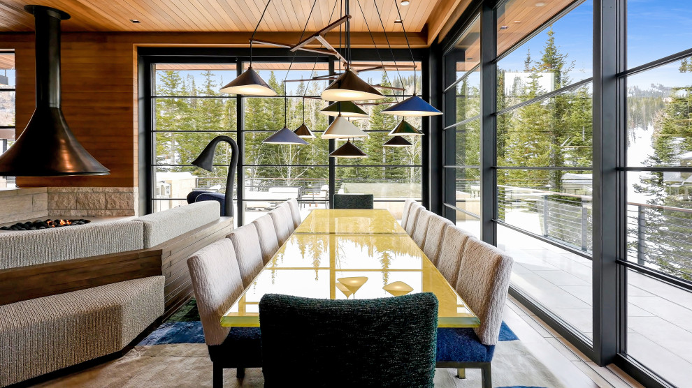 Cette image montre une grande salle à manger ouverte sur le salon minimaliste en bois avec un mur multicolore, un sol en bois brun, cheminée suspendue, un manteau de cheminée en pierre, un sol marron et un plafond en bois.