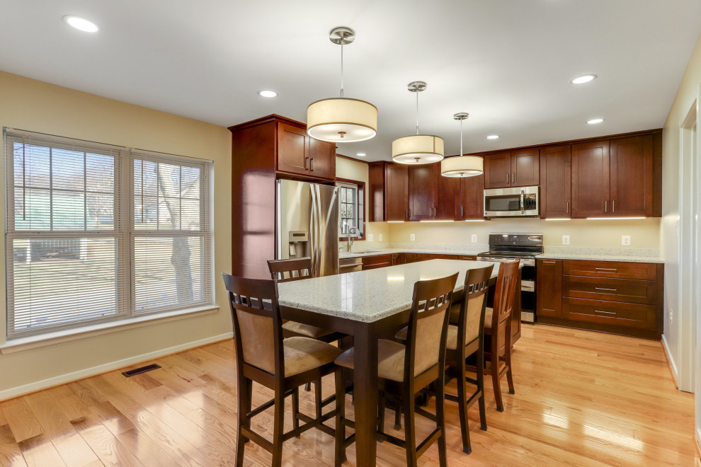 Photo of a large transitional l-shaped separate kitchen in DC Metro with an undermount sink, shaker cabinets, medium wood cabinets, quartz benchtops, stainless steel appliances, with island and multi-coloured benchtop.