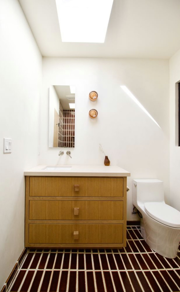 Exemple d'un WC et toilettes scandinave en bois brun de taille moyenne avec un placard en trompe-l'oeil, WC à poser, un mur beige, un sol en brique, un lavabo posé, un sol marron et meuble-lavabo encastré.