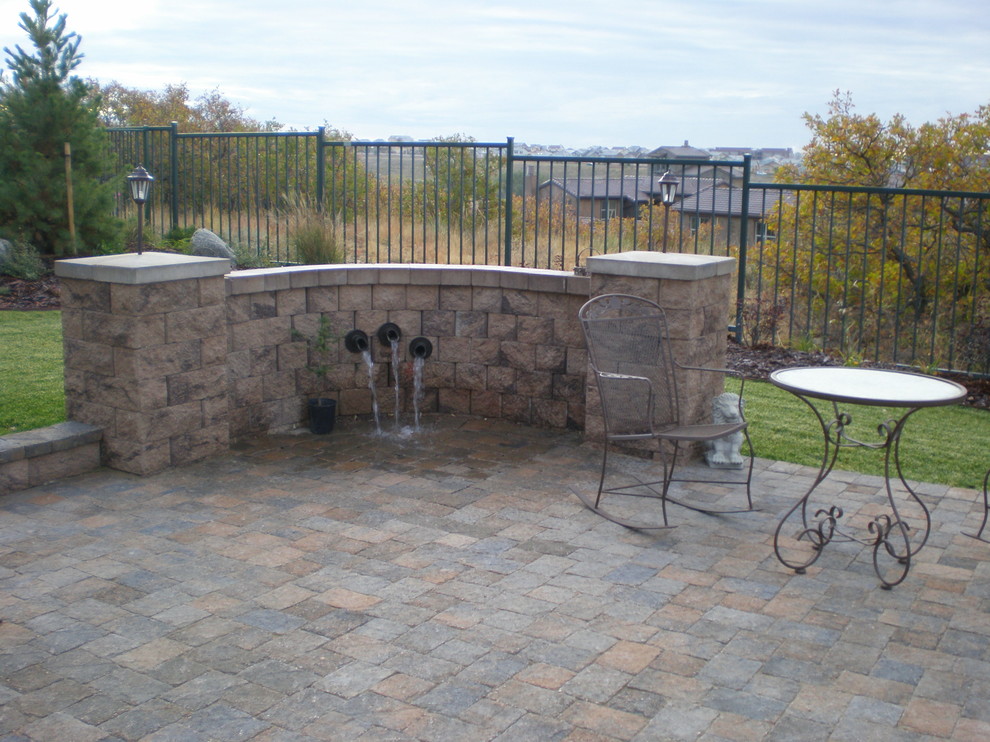Inspiration for a mid-sized arts and crafts backyard patio in Denver with brick pavers.