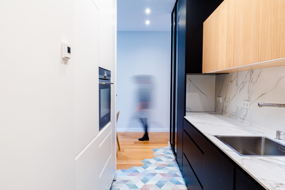 This is an example of a mid-sized contemporary galley kitchen in Madrid with an undermount sink, panelled appliances, porcelain floors, no island and multi-coloured floor.