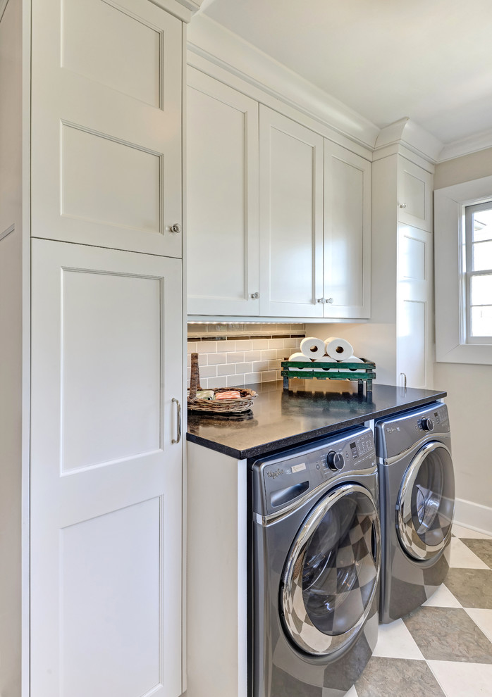 Transitional laundry room in Charleston with shaker cabinets, white cabinets, grey floor and black benchtop.