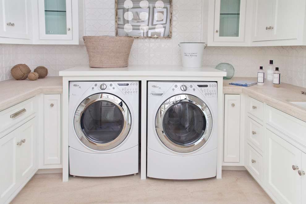 Beach style u-shaped dedicated laundry room in Orange County with an undermount sink, white cabinets, white walls, a side-by-side washer and dryer and beaded inset cabinets.