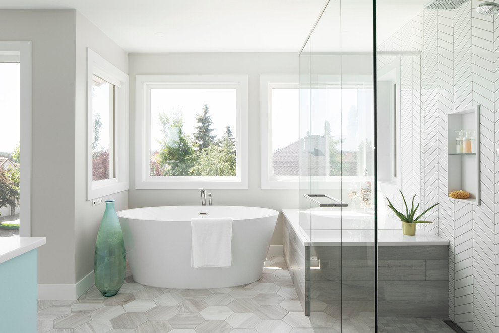 Photo of a large transitional master bathroom in Calgary with recessed-panel cabinets, blue cabinets, a freestanding tub, an alcove shower, porcelain tile, white walls, an undermount sink, engineered quartz benchtops, grey floor, a hinged shower door and white benchtops.