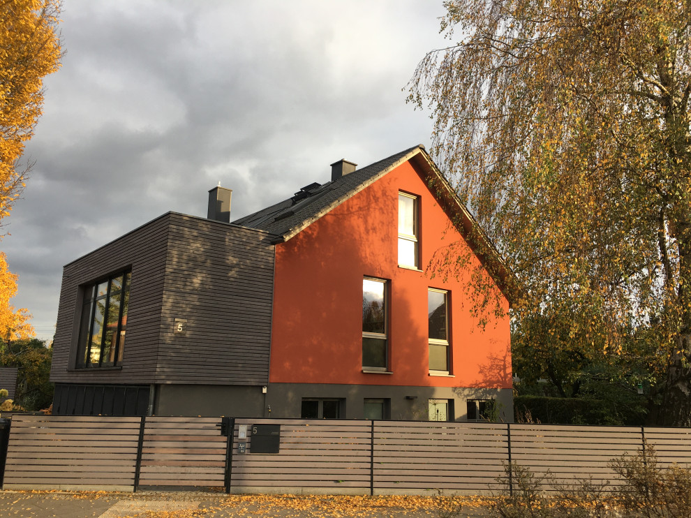 Design ideas for a medium sized modern bungalow house exterior in Berlin with wood cladding and shiplap cladding.
