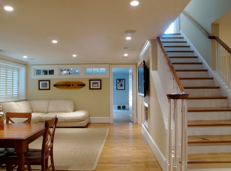 Inspiration for a large beach style look-out basement in Toronto with beige walls and light hardwood floors.
