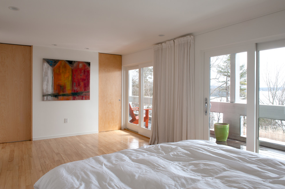 Photo of a contemporary master bedroom in Burlington with white walls and light hardwood floors.